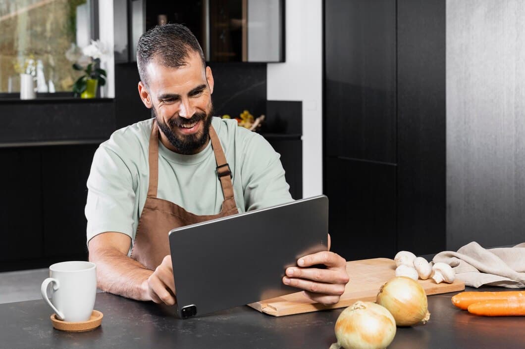 Dono de restaurante gerenciando pedidos em um tablet.